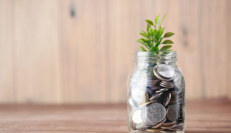 a glass jar filled with coins and a plant